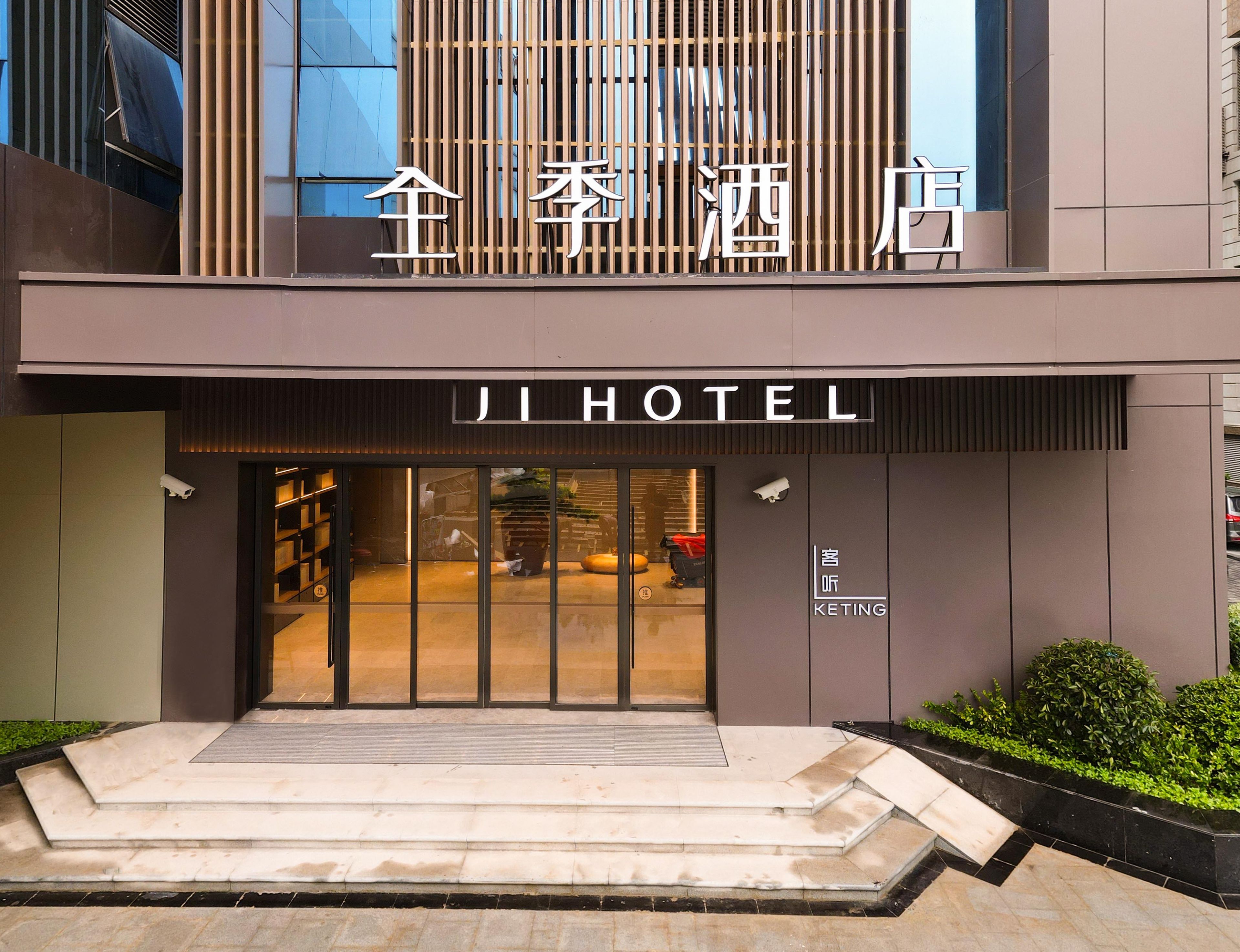 A modern hotel entrance with a large sign reading 'JI HOTEL' and a smaller sign below stating 'KETING'.