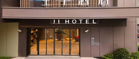 A modern hotel entrance with a large sign reading 'JI HOTEL' and a smaller sign below stating 'KETING'.