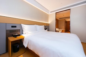 A hotel room with a bed, bedside table, and a trash bin. - Ji Hotel (Shanghai)