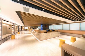 A modern hotel lobby with a reception desk, seating areas, and a clean, well-lit interior. - Ji Hotel (Shanghai)