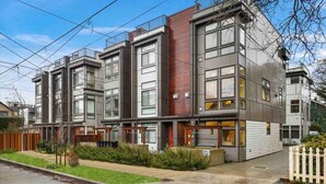 A modern multi-story residential building with large windows and a flat roof. - Modern 3 Bedroom in Queen Anne with Rooftop + AC (Seattle)