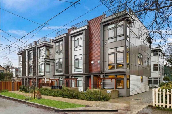 A modern multi-story residential building with large windows and a flat roof. - Modern 3 Bedroom in Queen Anne with Rooftop + AC (Seattle)