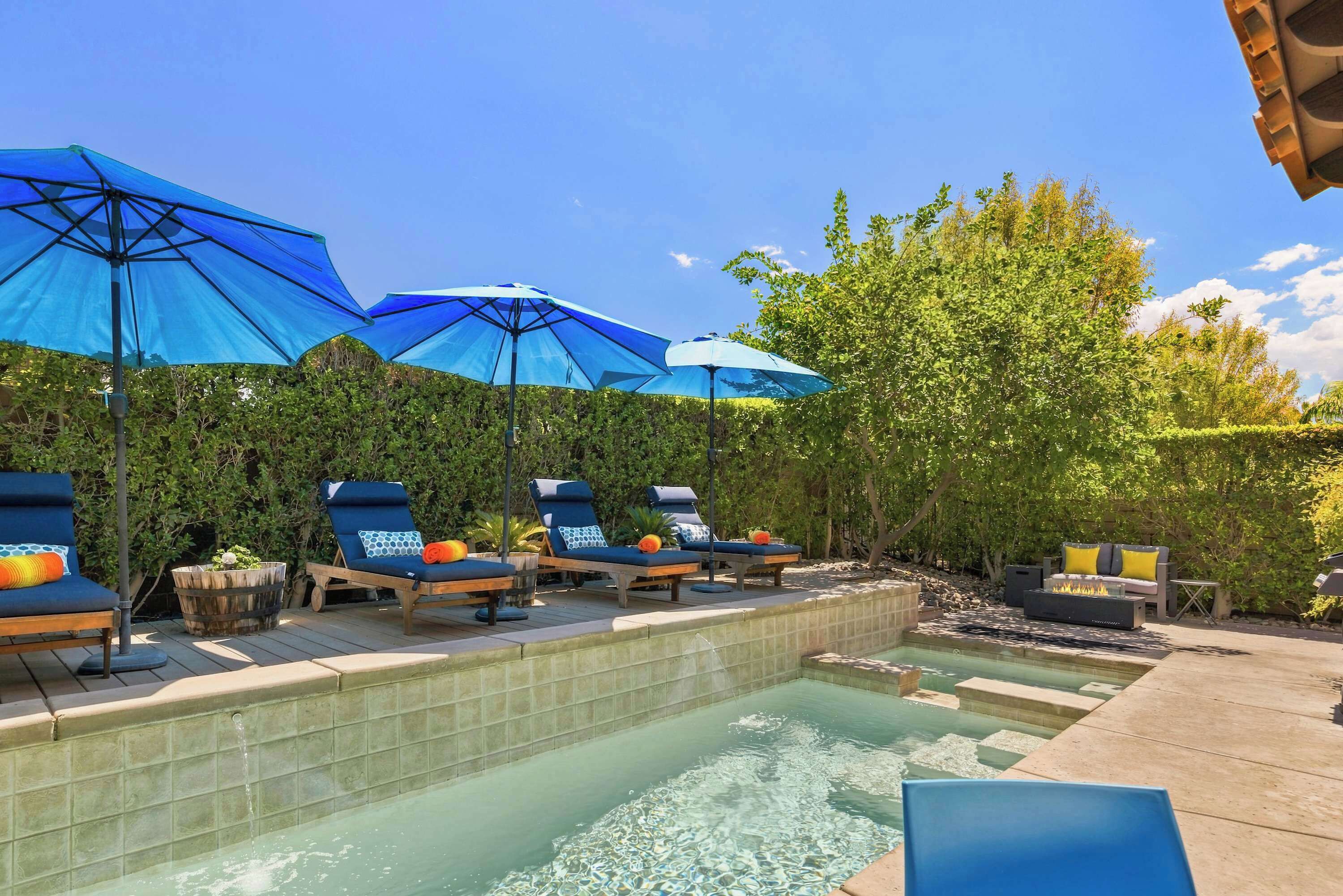 Un espace aménagé au bord de la piscine, avec des chaises longues et des parasols.