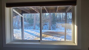 A window with a view of a snowy landscape and trees.