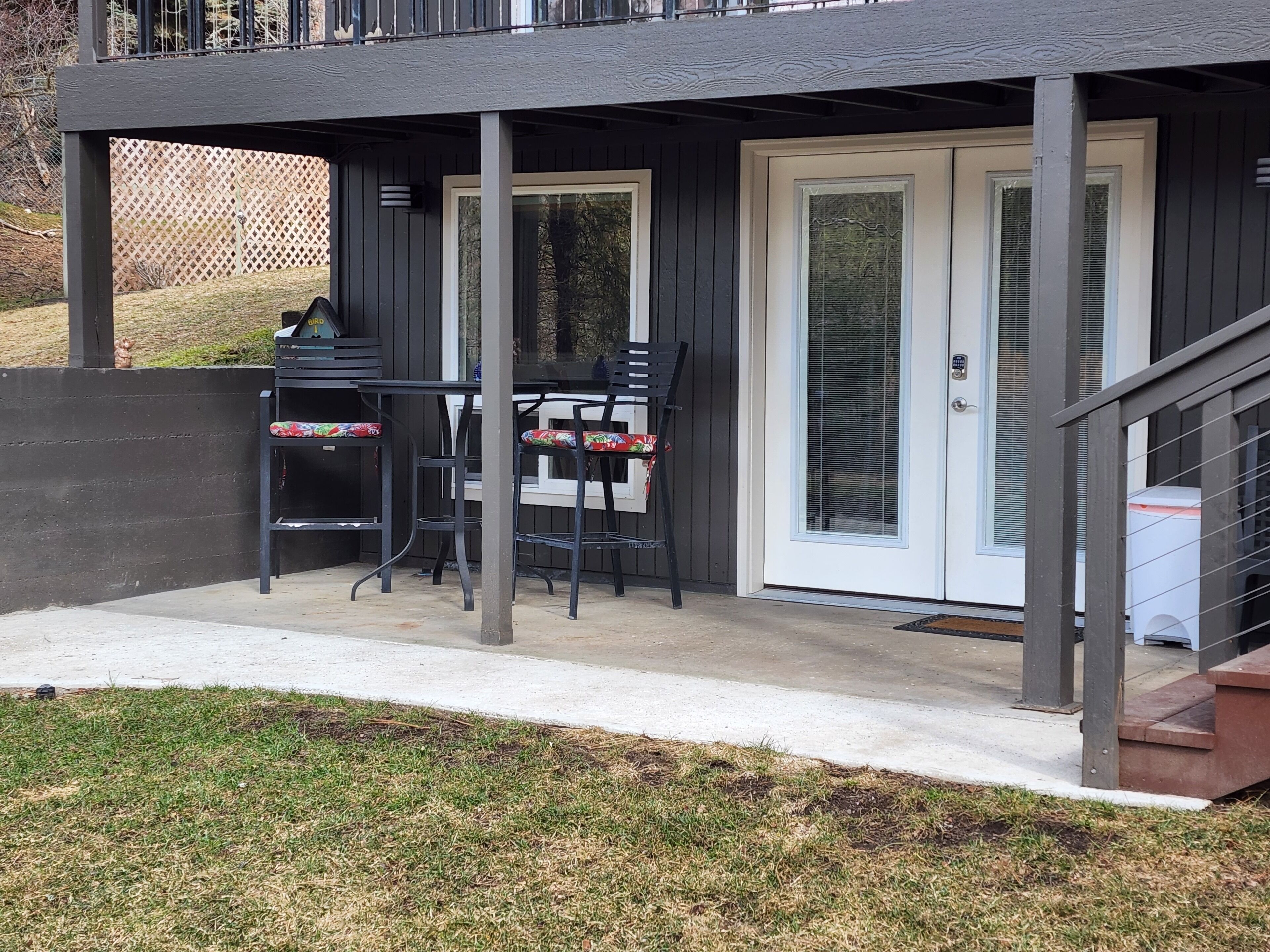 A covered patio area with a table and chairs, a sliding glass door, and a small outdoor kitchen area.