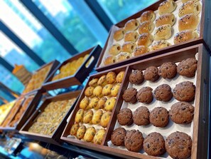 Een bakkerijvitrine met verschillende gebakjes in bakplaten.