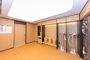 A modern bathroom with a skylight, a washing machine, and a shower area. - Ji Hotel (Nanjing)