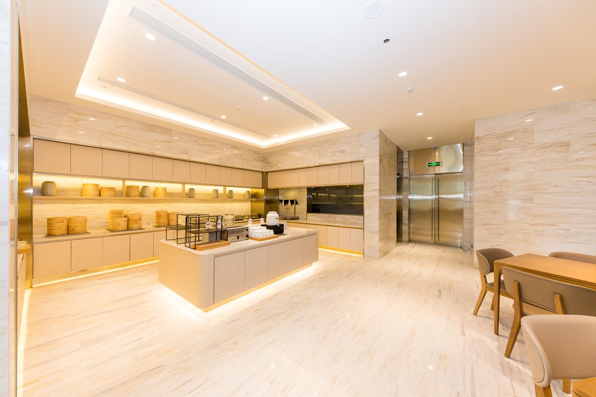 A modern kitchen with a central island, built-in appliances, and a dining area with a table and chairs.