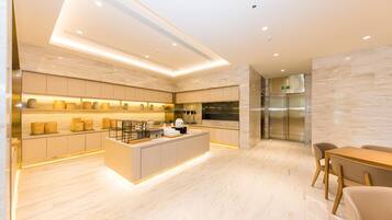 A modern kitchen with a central island, built-in appliances, and a dining area with a table and chairs.