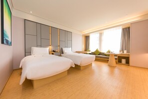 A hotel room with two beds, a sofa, a small table, and a large window with curtains. - Ji Hotel (Nanjing)