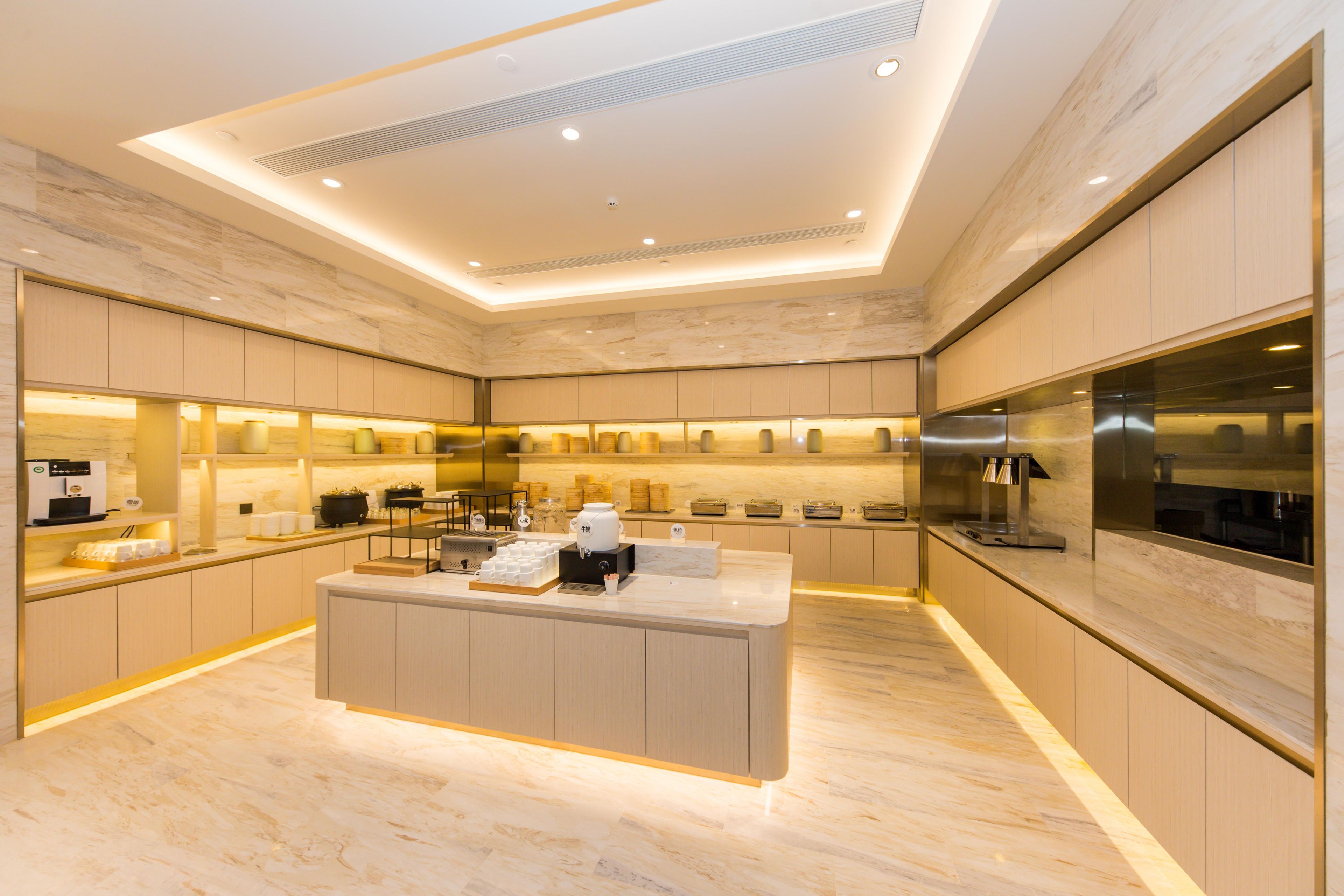A modern kitchen with marble flooring, built-in appliances, and a central island.