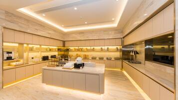 A modern kitchen with marble flooring, built-in appliances, and a central island.