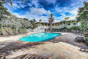 A swimming pool with lounge chairs and a building with a balcony. - Beach Club Cottage w/ Private Beach & Heated Pool (Sarasota)