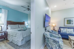 A bedroom with a bed, bedside table, and a ceiling fan. - Private Gated Beach & Heated Pool: Modern Siesta Key Cottage at Beach Club on Crescent Beach (Sarasota)