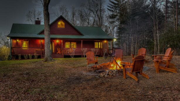Une cabane avec un foyer et des sièges d’extérieur.