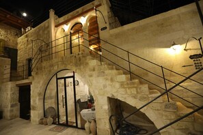 A stone building with a staircase leading to an upper level. There are signs indicating room numbers 201, 202, and 203. - Hancı Cave Hotel (Ürgüp)