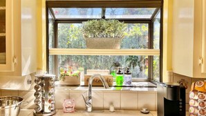 A kitchen with a sink, faucet, and various kitchen items. - Family Retreat • Pool • Air Hockey • King Suite (Chico)