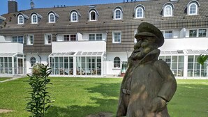 A building with multiple windows and a large sculpture in front.