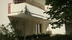 Un immeuble à plusieurs étages doté de balcons, d’une fenêtre et d’une porte.