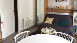 Un salon chaleureux avec un canapé, une table à manger et une petite table d’appoint.