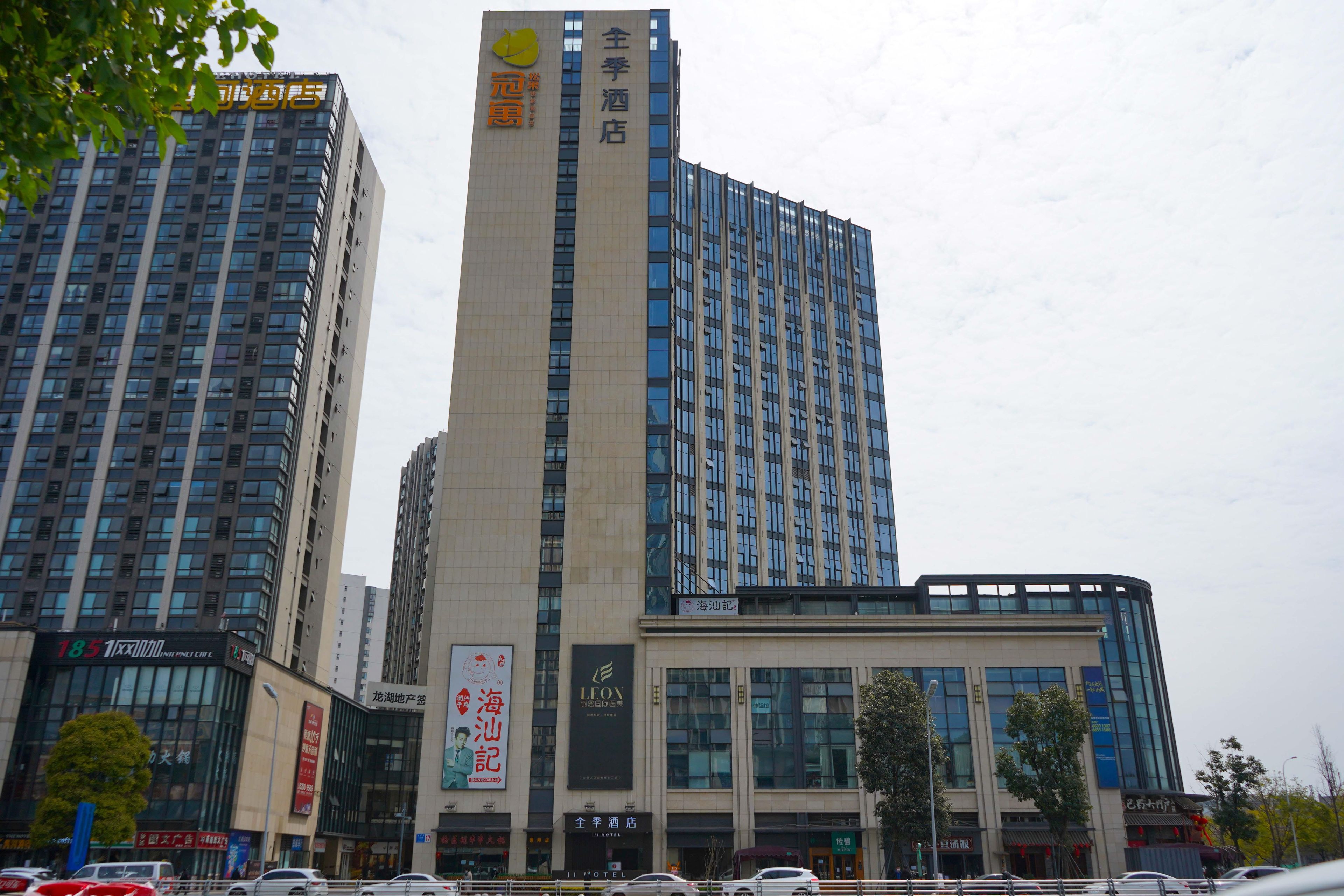 Un hôtel doté d’une enseigne verticale bien visible, de nombreuses fenêtres et d’une façade moderne.