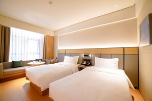 A hotel room with two beds, a sofa, a small table, and a window with curtains. - Ji Hotel (Chengdu)