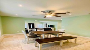 A dining area with a large table and chairs, a ceiling fan, and a tiled floor. - Cozy vacation home 5 mins from downtown!!! (Sarasota)