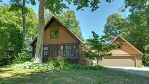 Ein zweistöckiges Holzhaus mit Balkon, Garage und gepflegtem Rasen.