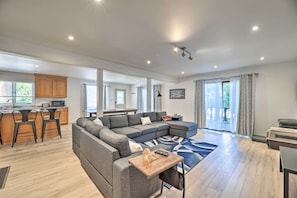 Relax in this stylish living space with a large sofa, coffee table, and kitchenette.