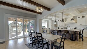 A spacious kitchen with a large island, wooden flooring, and modern pendant lighting. - 9 bdrm home, sleeps 26 w/ hot tub/gym/theatre/bar (Surrey)