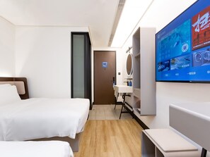 A hotel room with two beds, a desk, a mirror, and a TV screen displaying content. - Hanting Hotel (Beijing)