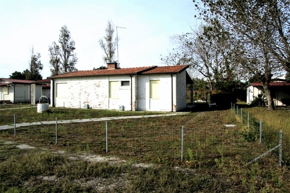 A small, single-story house with a red-tiled roof, a front door, and a window. - Peaceful Coastal Stay, Rosolina (Rosolina Mare (RO))