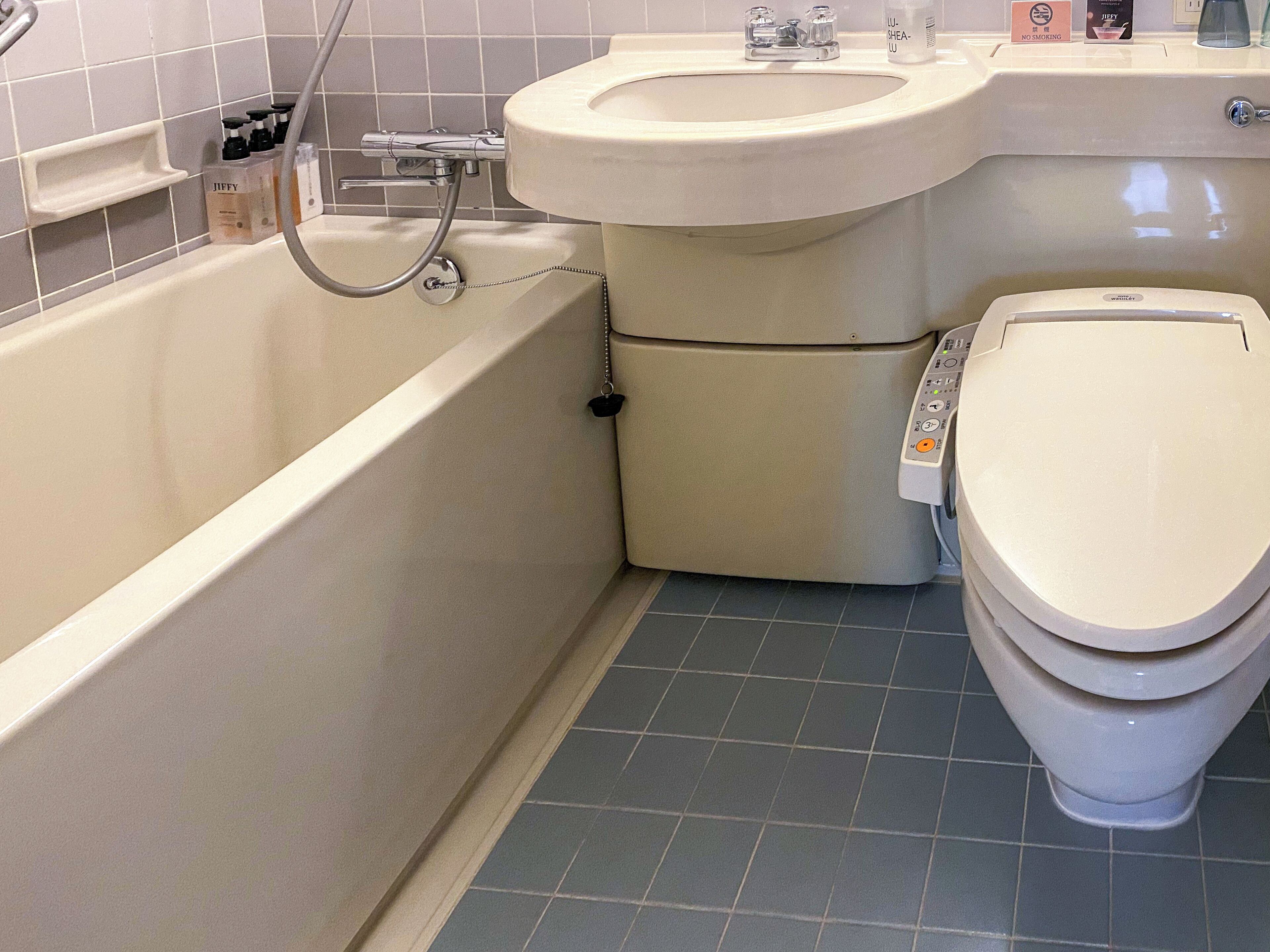 A bathroom with a bathtub, a toilet, and a sink.
