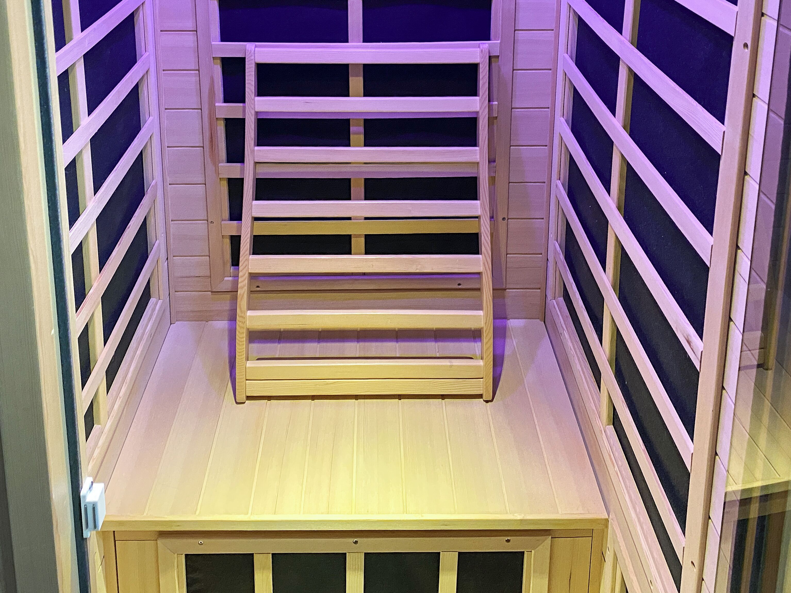 A room with a wooden bunk bed, a small table, and a window with blinds.