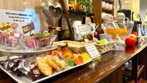 A buffet counter with various food items, including pastries, fruits, and drinks. - La Jolie Motomachi (Hakodate)