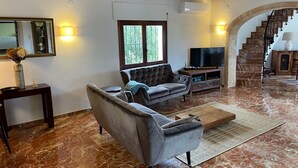 Ein Wohnzimmer mit Sofa, Fernseher und einer Treppe.