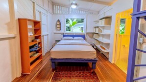 Une chambre à coucher avec un lit, des étagères et une fenêtre.