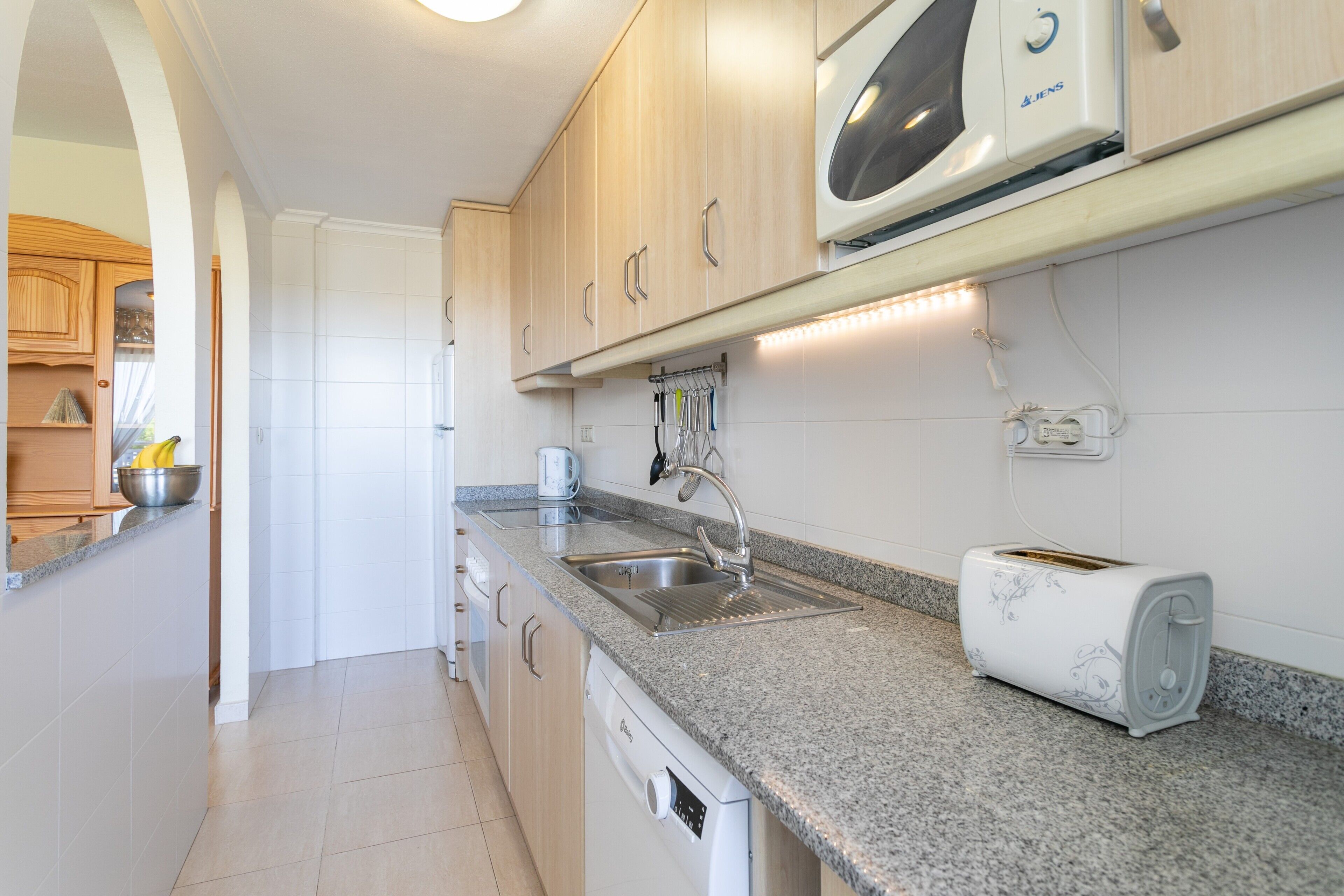 A kitchen with granite countertops, stainless steel appliances, and wooden cabinets.