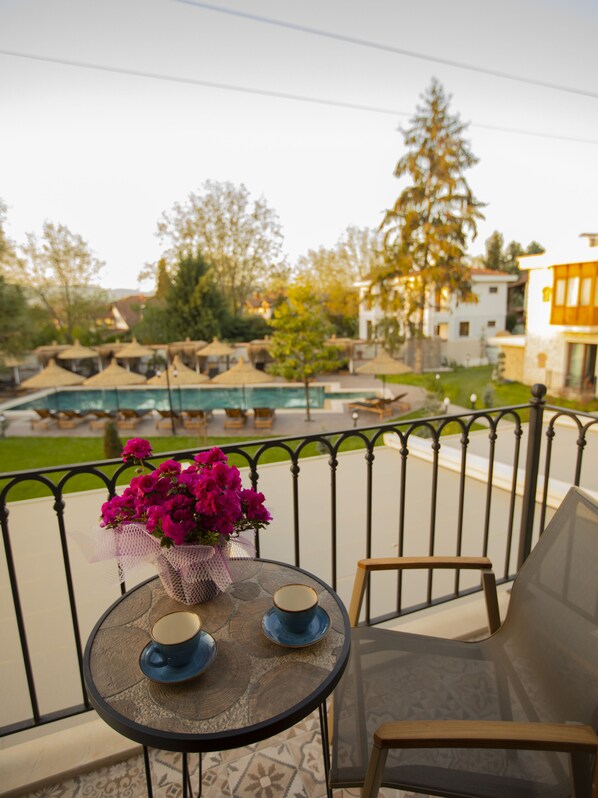 A balcony with a round table, two chairs, and a vase of flowers. - Balturk Garden Sapanca Hotel (Sapanca)
