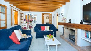 Una sala de estar con dos sofás, una mesa de centro, una chimenea y un televisor.