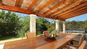 An outdoor wooden pergola with a dining table and chairs, a fruit bowl, and a ping pong table. - Country House "Casa Rei Vila" with Mountain View (Pollensa)