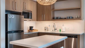 Eine moderne Küche mit Holzschränken, Edelstahlgeräten und einer weißen Arbeitsplatte.