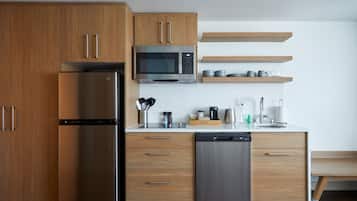 Cozinha moderna com armários de madeira, geladeira de aço inoxidável, micro-ondas e lava-louças.