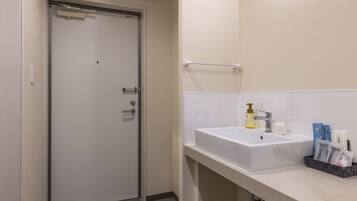 A bathroom with a white sink, a towel rack, and toiletries on the counter.