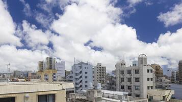 Un paisaje urbano con varios edificios, incluyendo una construcción blanca destacada que posee un elemento arquitectónico singular en el techo.