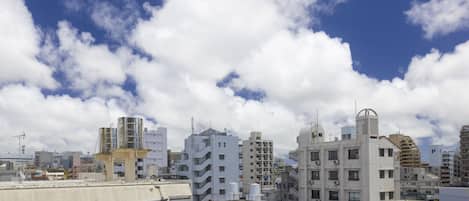 Un paisaje urbano con varios edificios, incluyendo una construcción blanca destacada que posee un elemento arquitectónico singular en el techo.