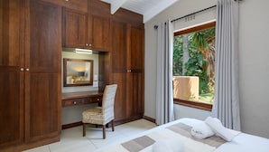 A bedroom with a large bed, a desk with a chair, and a window with curtains. - San Lameer Villa Rentals 3215 (Southbroom)