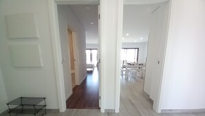 A hallway leading to a dining area with a kitchen in the background. - Alto Forte Novo 4, Vista Mar, Ar Condicionado e Garagem (Quarteira)