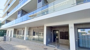 A multi-story building with balconies, a ground-level entrance, and a sign indicating 'LOT 1.17.2'. - Alto Forte Novo 4, Vista Mar, Ar Condicionado e Garagem (Quarteira)
