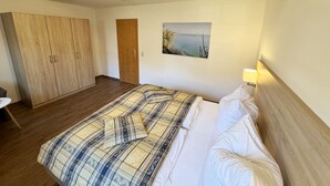 Ein Schlafzimmer mit einem Bett, einem Holzschrank und einem Bild an der Wand.